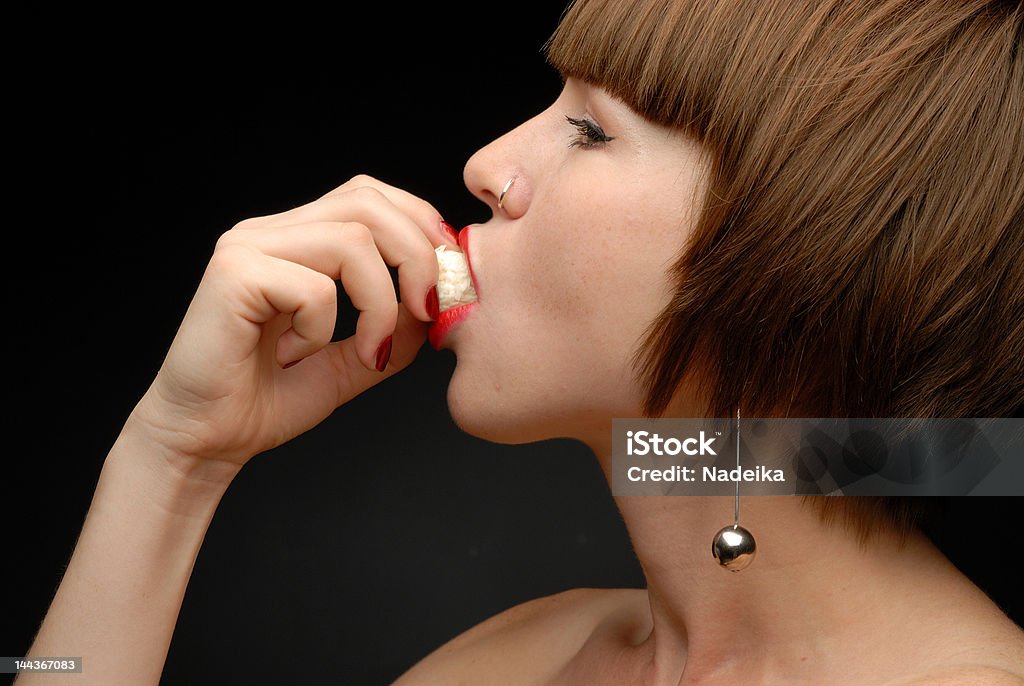 Links Profil von Frau putting-Süßigkeit in Ihrem Mund - Lizenzfrei Angebissen Stock-Foto