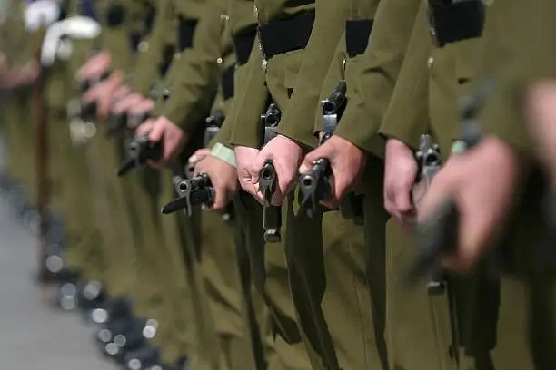 Line of New Zealand Army Soldiers with bayonets fixed, standing at ease.
