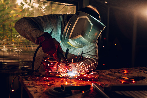 Metal worker using a grinder