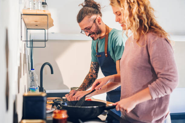 istock Young couple making breakfast together in the kitchen at home 1443675435