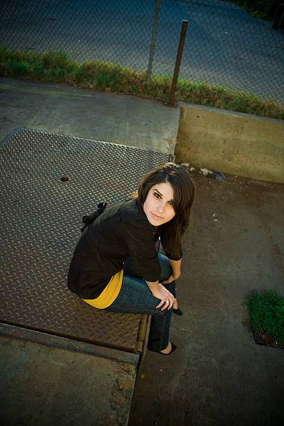 young woman sitting outdoor stock photo