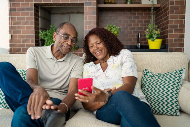 istock African American senior couple using smart phone in the sofa 1443682880