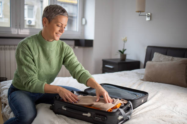 istock Mid adult woman packing suitcase 1443683709