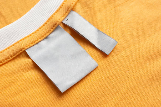 istock Blank white laundry care clothes label on yellow fabric texture background 1443686736