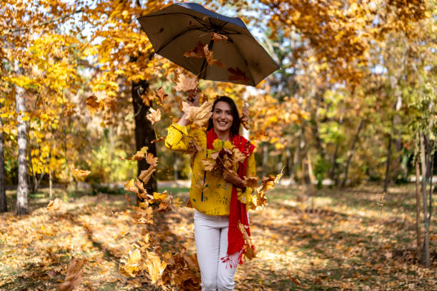istock Beautiful woman among falling autumn leaves 1443688429