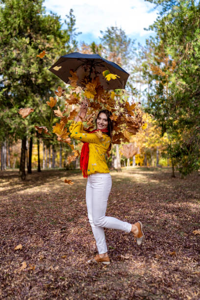 istock Beautiful woman among falling autumn leaves 1443688432