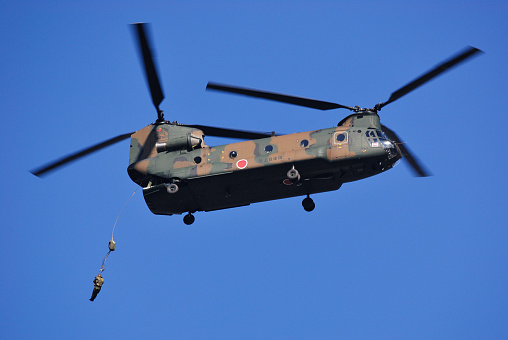 Chiba Prefecture, Japan - January 10, 2010: Japan Ground Self Defense Force paratroopers jump out the back of a CH-47J Chinook heavy-lift helicopter.
