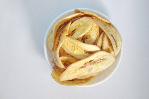 istock Banana chips in a white plate on a white background 1443695947