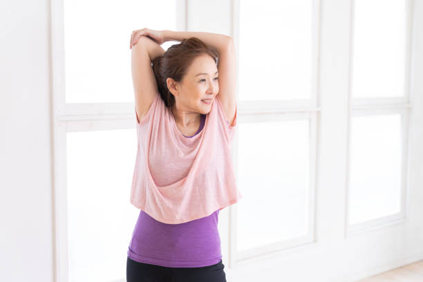 senior age woman exercising in the room stock photo