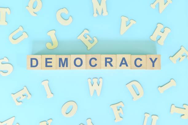 istock Democracy government form concept. Wooden blocks typography flat lay in blue background. 1443712868