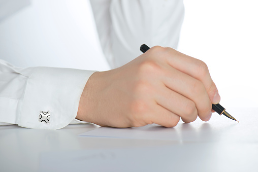 Businessman with Dollar sign cufflinks signing a contract