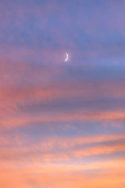 istock Hazy crescent moon glowing in a vibrant pink sunset sky 1443725217