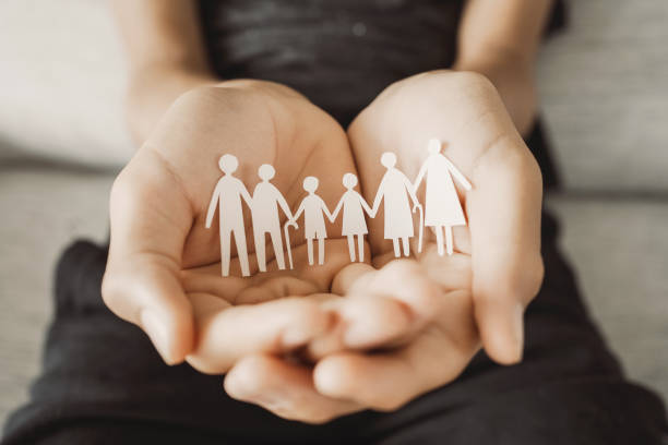 Hands holding multi generation family paper, family wellness, health insurance concept stock photo