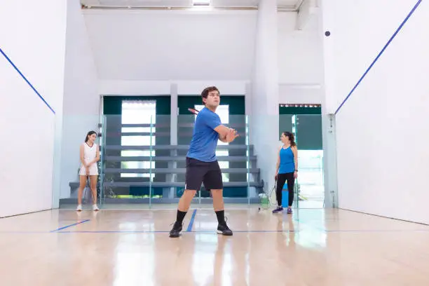 Photo of Squash team bouncing balls to the wall, front view