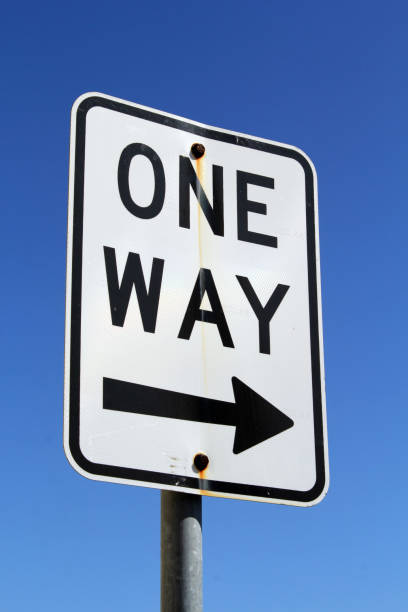 istock One way street road sign against a blue sky background 1443733576