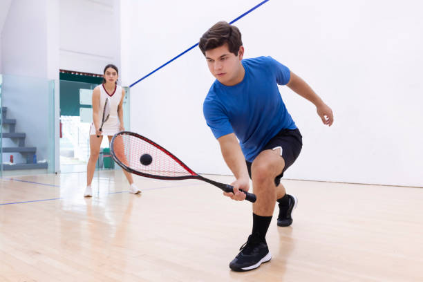 jeune homme en action avec sa raquette - racketball racket ball court photos et images de collection