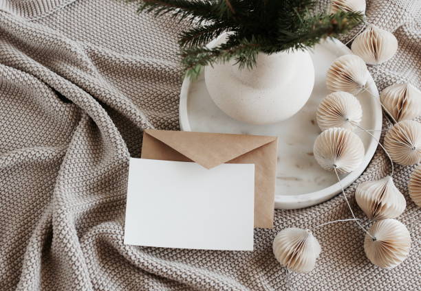 istock Blank greeting card, invitation mock up,craft envelope,beige knitting blanket, Christmas tree branches in a vase, decorations in marble tray top view.Xmas  scene still life neutral colors.Copy space 1443734950