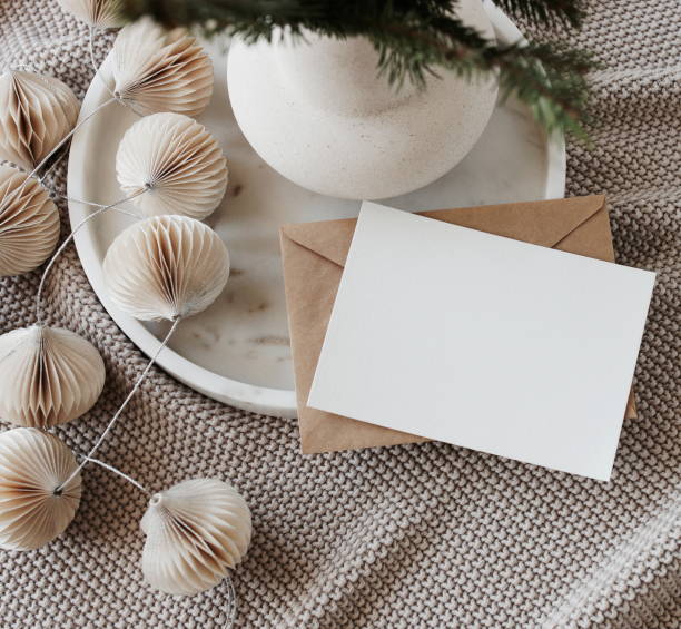 istock Blank greeting card, invitation mock up,craft envelope,beige knitting blanket, Christmas tree branches in a vase, decorations in marble tray top view.Xmas  scene still life neutral colors.Copy space 1443735047