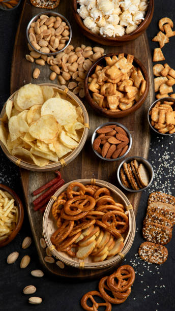 istock Assortment of salty snacks on dark background. 1443747537