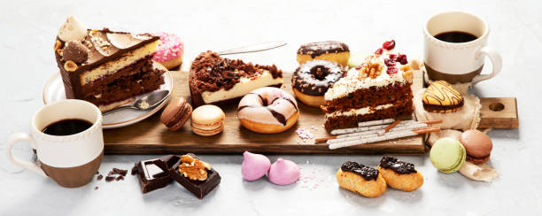 istock Table with various cakes, cookies, donuts and coffe cups on light background. 1443747829