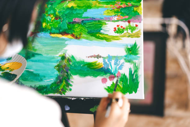 Woman painting brush on canvas at workshop art lesson class