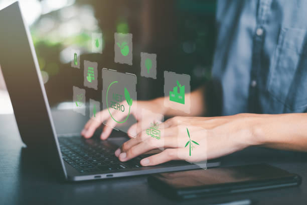 istock man and laptop on table, nature background,Net Zero and Carbon Neutral Concepts, a businessman in charge of green renewable energy technologies,save world,global warming campaign, green energy 1443751574