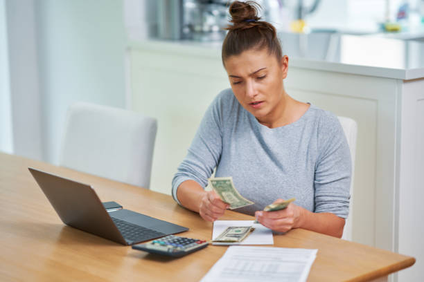 istock Young woman counting home budget with bills 1443754842