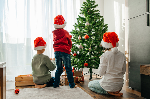 New Year and Merry Christmas. Children prepare for the holiday and decorate the Christmas tree with toys.