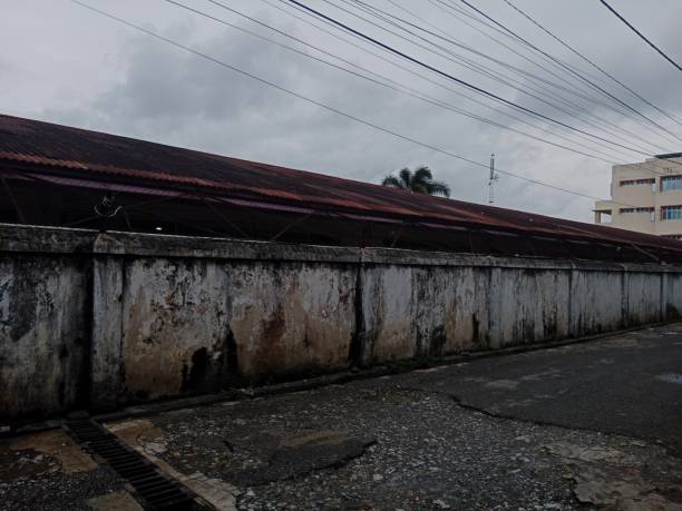 istock Classic wall fence, worn roof, clouds background 1443771534