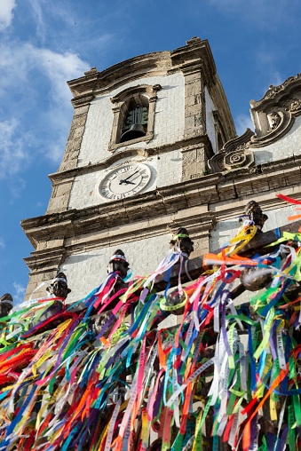 Salvador, Brazil – May 09, 2022: A vertical low angle shot of colorful decorations against the Senhor do Bonfim church in Salvador