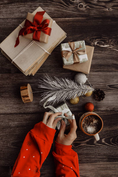 istock Wrapping small Christmas presents, on brown background 1443774898