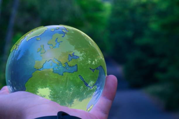 istock Hand holding a transparent glass earth ball 1443777378