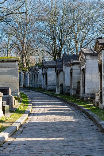 Paris, the Pere-Lachaise cemetery, cobbled alley with graves in winter