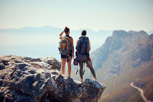 Nature, travel and hiking woman on mountain landscape with fitness, wellness and workout on summer day. Freedom, rock sport and women or couple with backpack, health and sports exercise or training