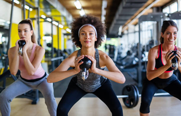 istock Group of fit people lifting dumbbells during an exercise class at the gym 1443788772