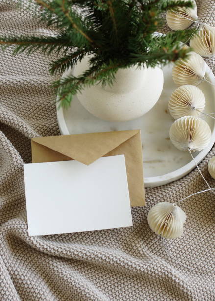 istock Blank greeting card, invitation mock up,craft envelope,beige knitting blanket, Christmas tree branches in a vase, decorations in marble tray top view.Xmas  scene still life neutral colors.Copy space 1443788837