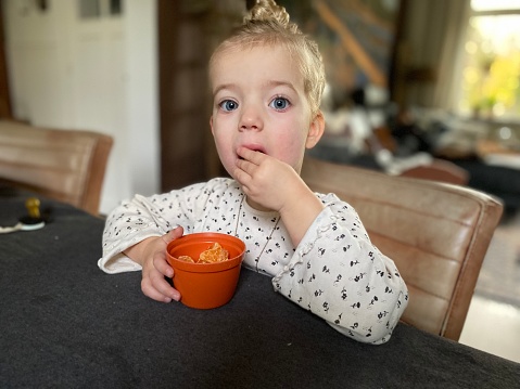 Tangerine eating toddler girl in close up
