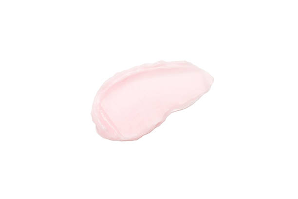 Smear of pink cosmetic cream isolated on white background close-up. stock photo