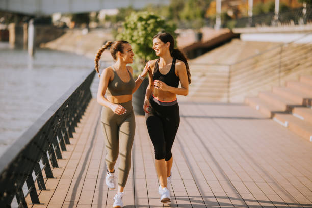 istock Young woman taking running exercise by the river promenade 1443801744