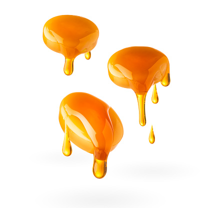 XL file of three caramel candies dripping caramel sauce isolated on white background