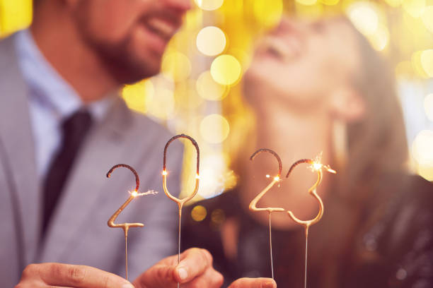 Couple at new year eve party with 2023 sparklers stock photo