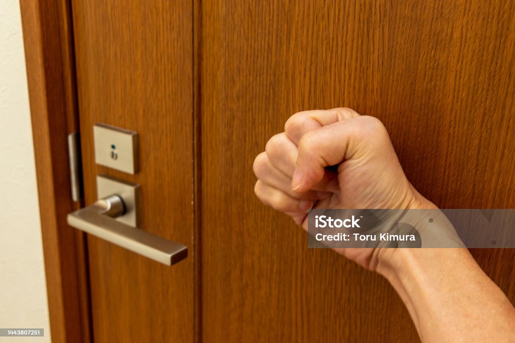 Knock on the door with a hand Toilet Stock Photo