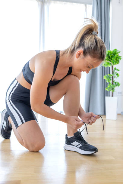 istock Fit woman smiling when tying shoe laces 1443809116