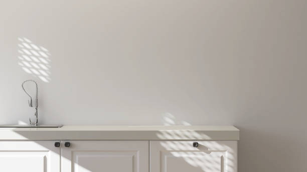 istock Modern, cozy and minimal cream colored kitchen cabinet counter with laminated top, stainless sink in sunlight from window on blank white wall 1443809740