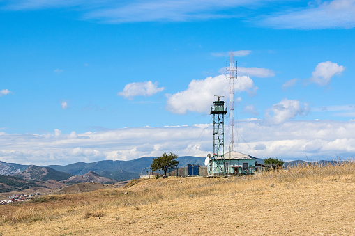 koktebel, crimea - september 20, 2022: base station of cellular communication with a tower and a house of residence