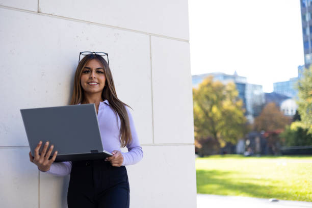 istock Woman in purple long sleeve shirt and notebook computer. 1443815385
