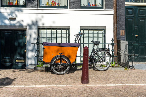 Downtown centre Amsterdam. Cargo bike for kids  and parking pole in Amsterdam. All parents in Amsterdam use these cargo bikes for transporting their kids to school, sports and shopping.