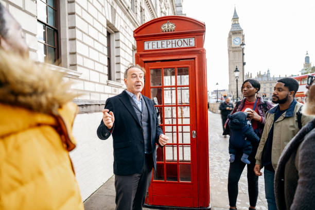 schwarze familie bei einem rundgang durch london mit guide - english culture talking men listening stock-fotos und bilder