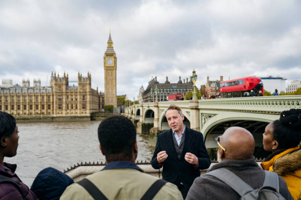 ロンドンのウォーキングツアーを楽しむ秋の行楽客 - english culture talking men listening ストックフォトと画像