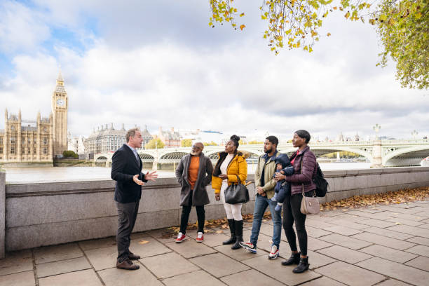 gruppo di vacanze che ascolta la guida, south bank london - english culture talking men listening foto e immagini stock